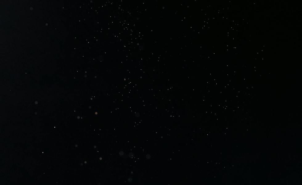 tiny white dust particles on black background