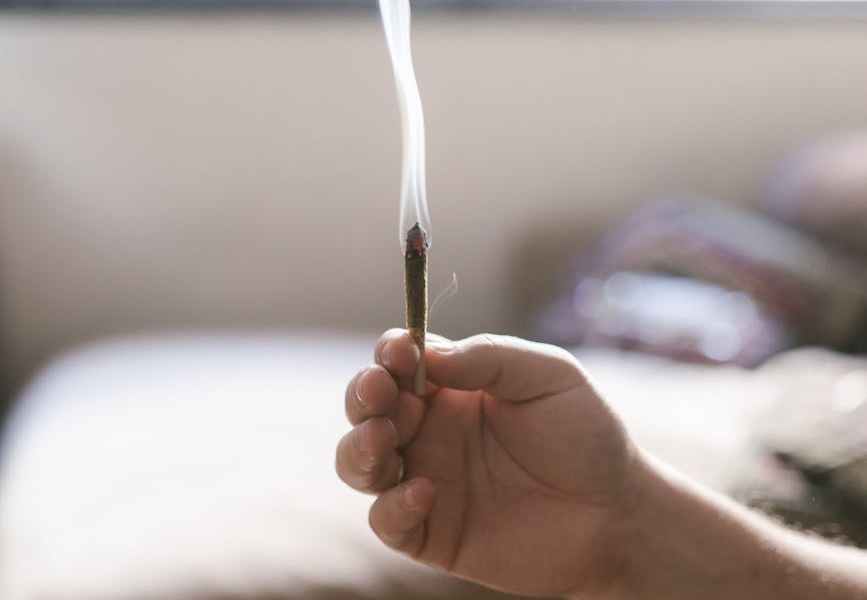 selective focus of a person holding a rolled weed